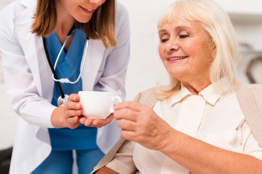 nurse giving tea old woman close up